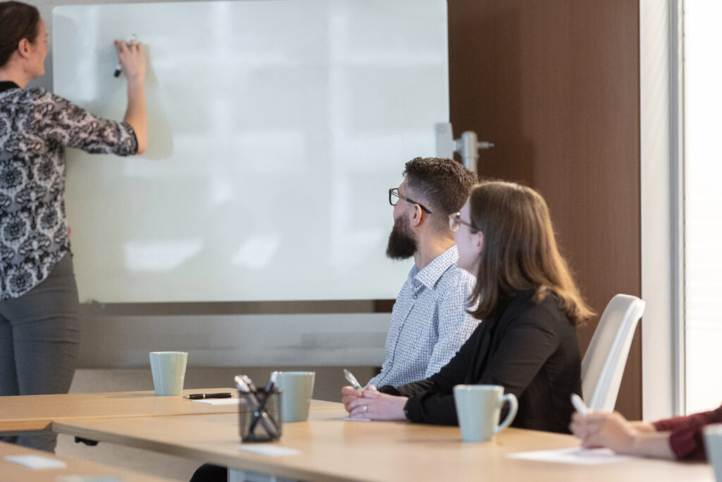 Staff at Welch LLP in a meeting room looking at a board