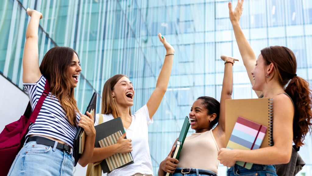 Students with their arms raised in the air in celebration